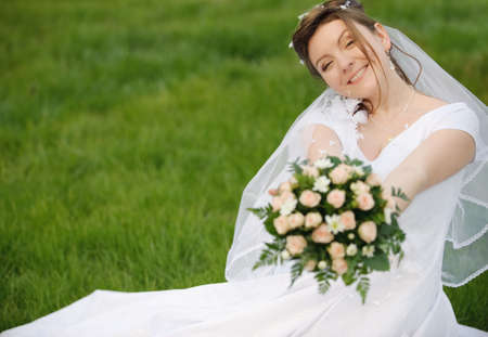 The bride on a lawn. The young girl in a wedding dress.の写真素材