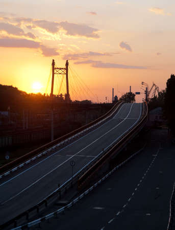Asphalt road and bridge. Highway, night time, yellow sunset