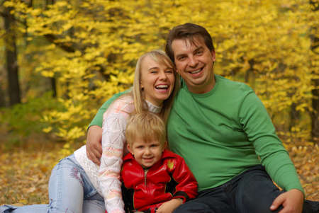 Family. Mum, the daddy, the son in autumn forest. Effective blur a backgroundの写真素材