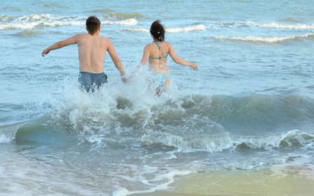 Pair on seacoast. The enamoured guy and the girl walking on coastの写真素材