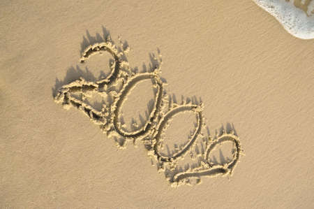 Inscription "2009" on sand. Sea coast with a rolling wave on an inscriptionの写真素材