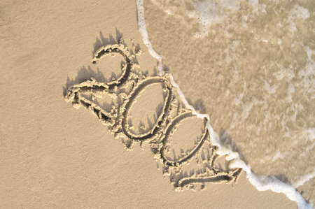 Inscription &quot,2009&quot, on sand. Sea coast with a rolling wave on an inscriptionの写真素材