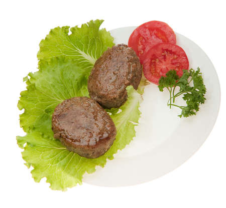 Cutlets with vegetables on a plate. It is isolated on a white backgroundの写真素材
