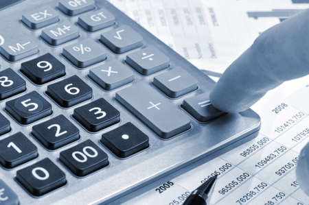 The calculator and a hand of the man. Pressing of a key of the calculatorの写真素材