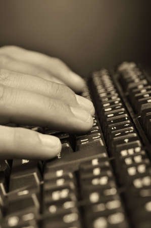 Hands above the keyboard. On a dark background, the black keyboardの写真素材