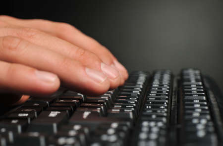 Hands above the keyboard. On a dark background, the black keyboard