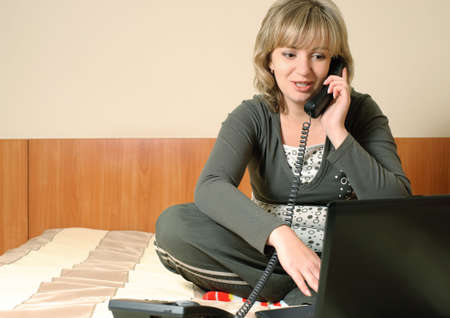 The young woman leading the business of the house on a sofa. House conditionsの写真素材