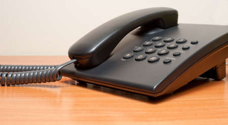 Phone on a table. device for conveying sounds over great distances by changing the sounds into electrical impulsesの写真素材