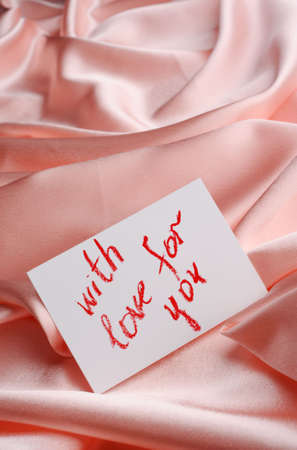 Note on beige  silk. With an inscription " With love for you ". Drawn by lipstickの写真素材