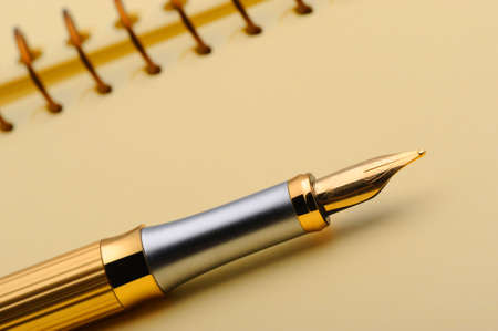 Fountain pen on a yellow notebook. Photo closeupの写真素材