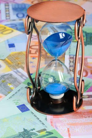 Time of money. A sand-glass and the European currencyの写真素材