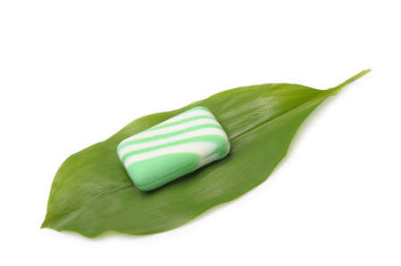 Soap on a green leaf of a lily of the valley. It is isolated on a white background.の写真素材