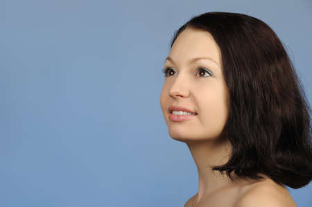 The beautiful young woman. Natural beauty. It is isolated on a blue backgroundの写真素材