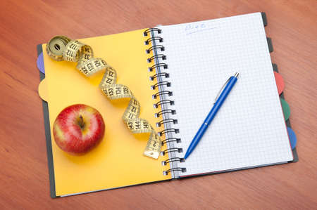 Planning of a diet. A notebook c an inscription - the Diet, a measuring tape, an apple and penの写真素材