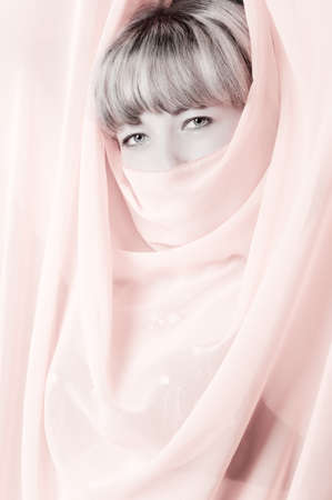 The woman close up. Face partially covered pareo. Toned image.の写真素材