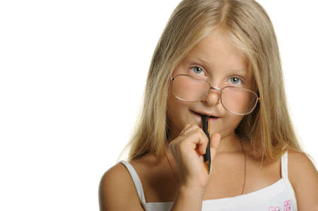The thoughtful girl the blonde in glasses and with pen. It is isolated on a white backgroundの写真素材
