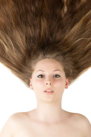 Healthy beautiful long hair closeup in motion created by wind. Isolated on whiteの写真素材