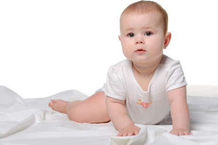 The baby on a bedsheet. Age of 8 months. It is isolated on a white backgroundの写真素材