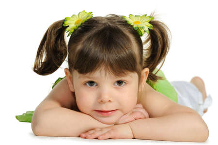 Pretty the little girl lies on the white. It is isolated on a white backgroundの写真素材