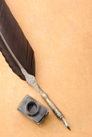 Feather quill and inkwell on an old paper. Photo closeupの写真素材