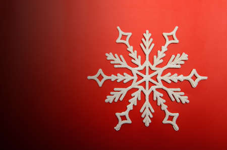 The big snowflake on a red background. Closeupの写真素材