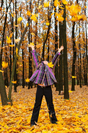 The girl with the lifted hands autumn forest. Falling yellow leafの写真素材