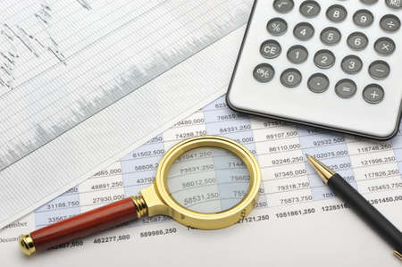 The calculator,loupe and the financial report. A workplace of the businessmanの写真素材