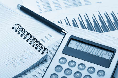 The calculator and the financial report blue toned. A workplace of the businessmanの写真素材