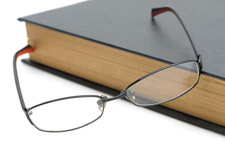 Eyeglasses on the old thick book. Isolated on white backgroundの写真素材