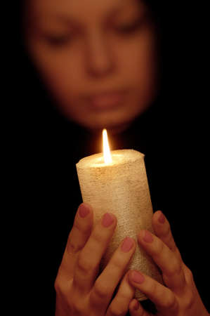The woman with burning candle. Selective focus on a candleの写真素材