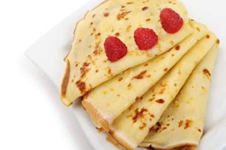 Crepe on a plate with a raspberry. A detailed photo fried thin pancake.Isolated on whiteの写真素材
