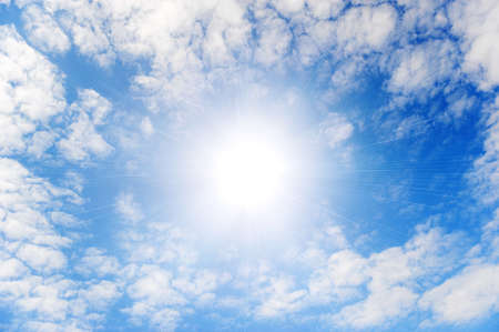 Shining sun with beams in the centre of clouds.Small wavy cloudsの写真素材