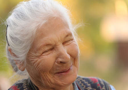 Portrait of the laughing elderly woman. A photo on outdoorsの写真素材
