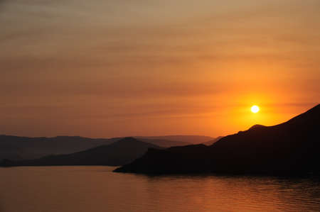 Colourful decline over mountains and the sea.の写真素材