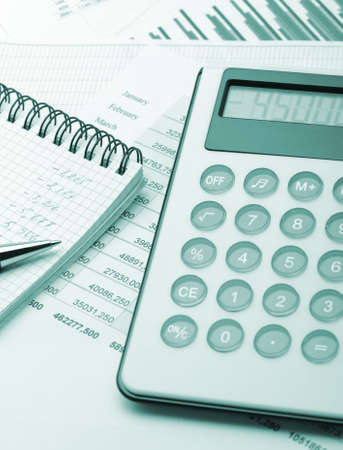 The calculator and the financial report blue toned. A workplace of the businessmanの写真素材