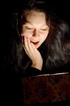 The woman with a gift box. Emotion a surprise. Light from a box.の写真素材