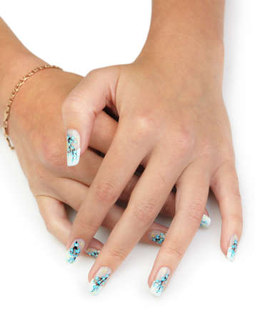 Female hands with manicure close up. Drawing of a branch with blue flowers. It is isolated on a white background.の写真素材