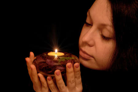 The woman with burning candle. Selective focus on a candleの写真素材