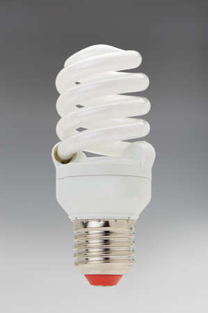 Energy saving compact fluorescent lightbulb on a grey gradientの写真素材