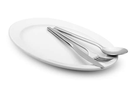 Spoon, fork and a knife lie on a plate. It is isolated on a white backgroundの写真素材