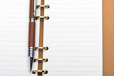 Open notebook with copper binding and stylish pen.の写真素材