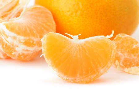 Segments and the whole tangerine. A detailed photo of fruit on a white backgroundの写真素材