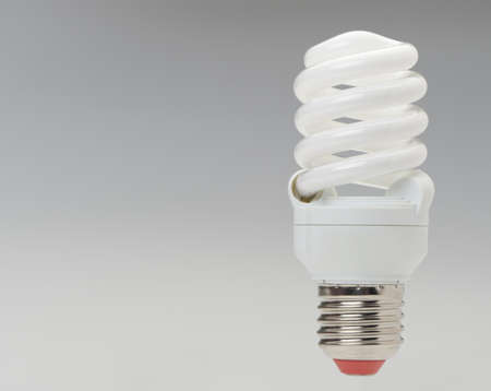 Energy saving compact fluorescent lightbulb on a grey gradientの写真素材