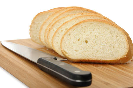 The cut bread on a chopping board with a knife. It is isolated on a white backgroundの写真素材