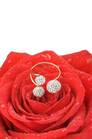 Red rose with a ring with jewels and water drops. A photo closeup.Isolated on whiteの写真素材