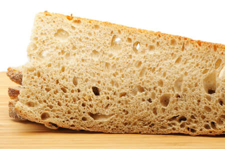 The cut bread on a chopping board. It is isolated on a white backgroundの写真素材