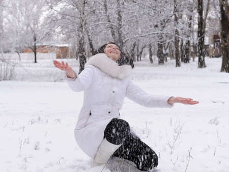 The woman in white and falling snowの写真素材