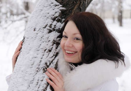 Portrait of the young woman in white at a tree. Winter timeの写真素材