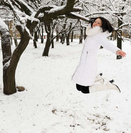 The girl jumps in winter forest. Winter seasonの写真素材