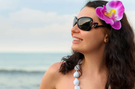 Portrait of the beautiful woman on seacoast. A profile, sun glassesの写真素材